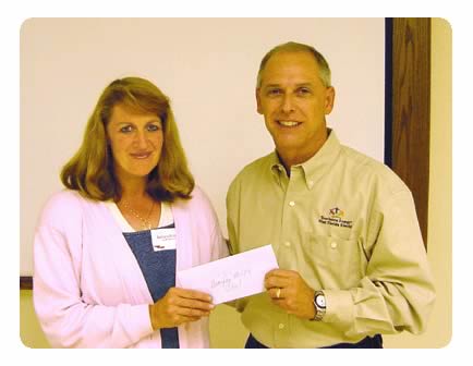 WFEC Communications Supervisor John Thornton presents a $200 check to Bonifay middle school teacher Barbara Rutledge for 
her schools science department.